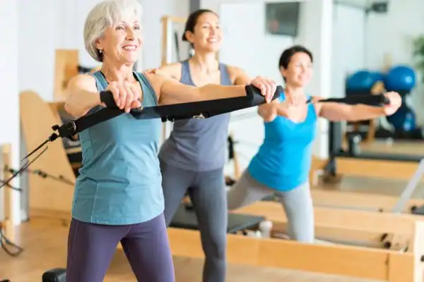 older woman doing weight training Wisley and resistance in the gym to tone upper arms