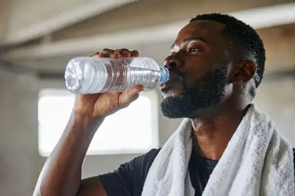 Image of man drinking water to improve hydration Wisley after work out.